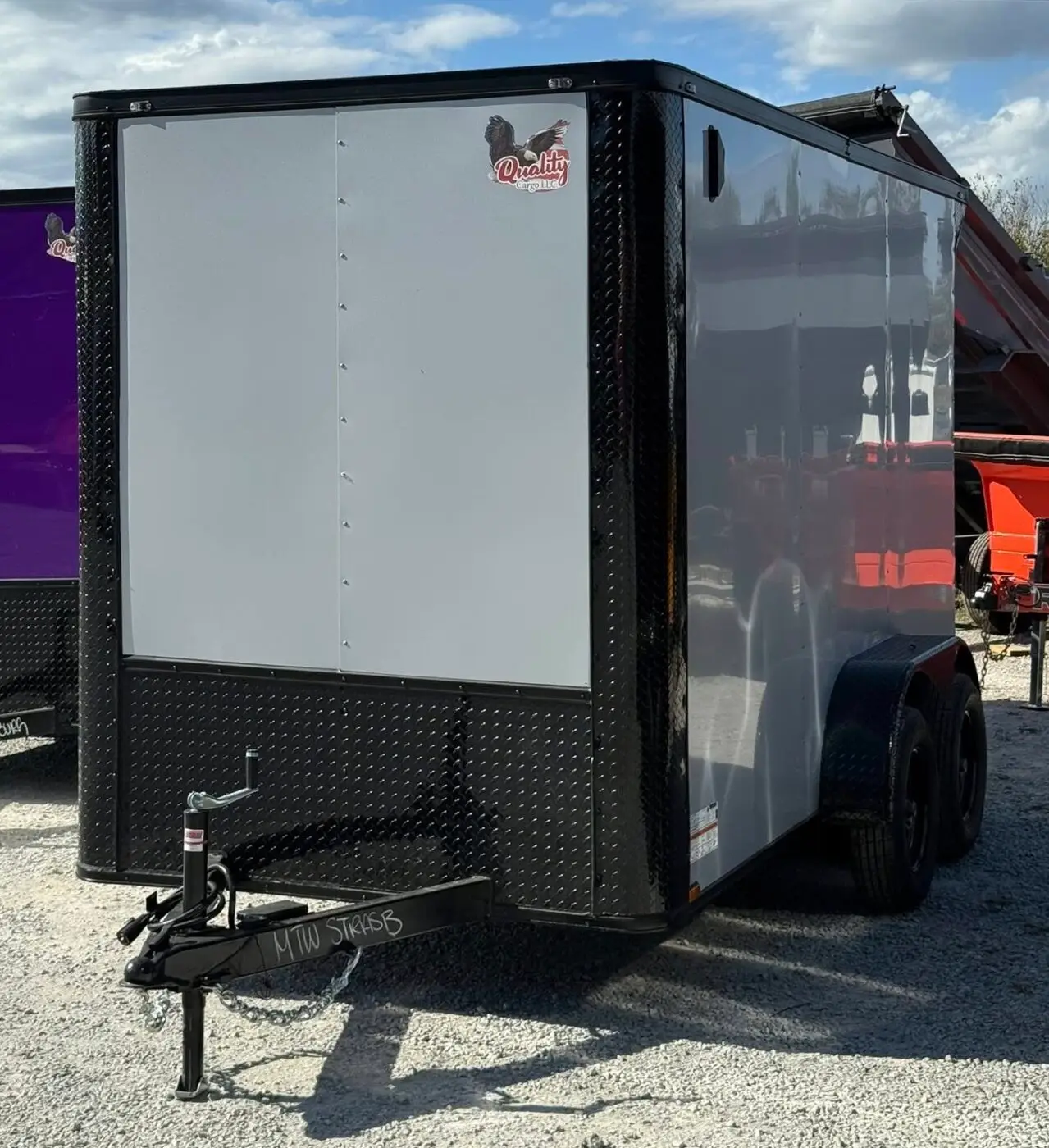Gray enclosed cargo trailer on gravel lot