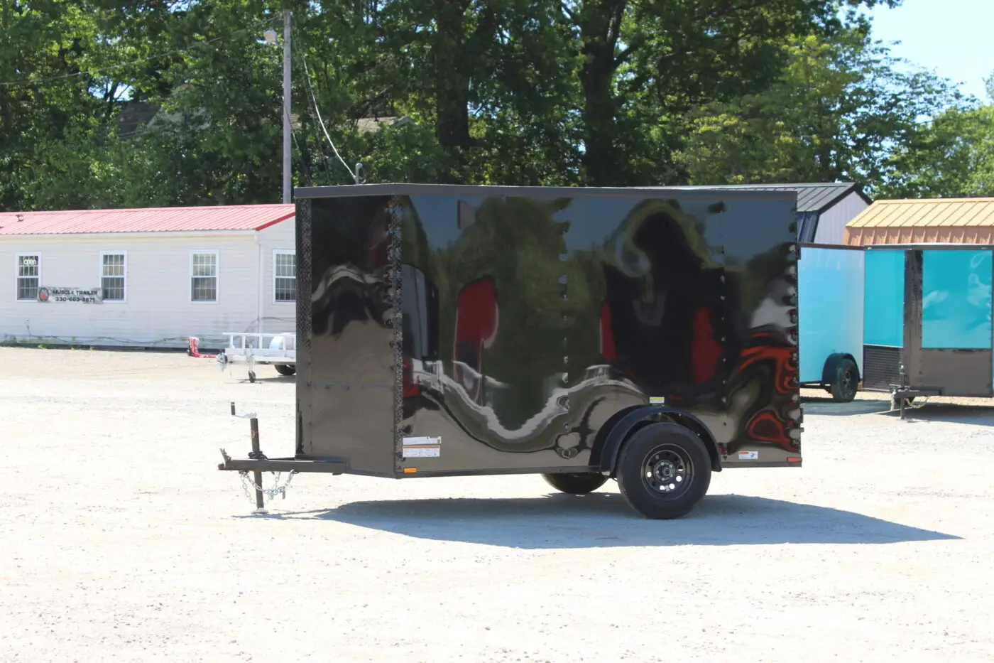 Black enclosed cargo trailer on gravel lot
