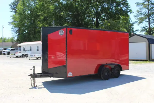 Red enclosed dual-axle cargo trailer on gravel lot