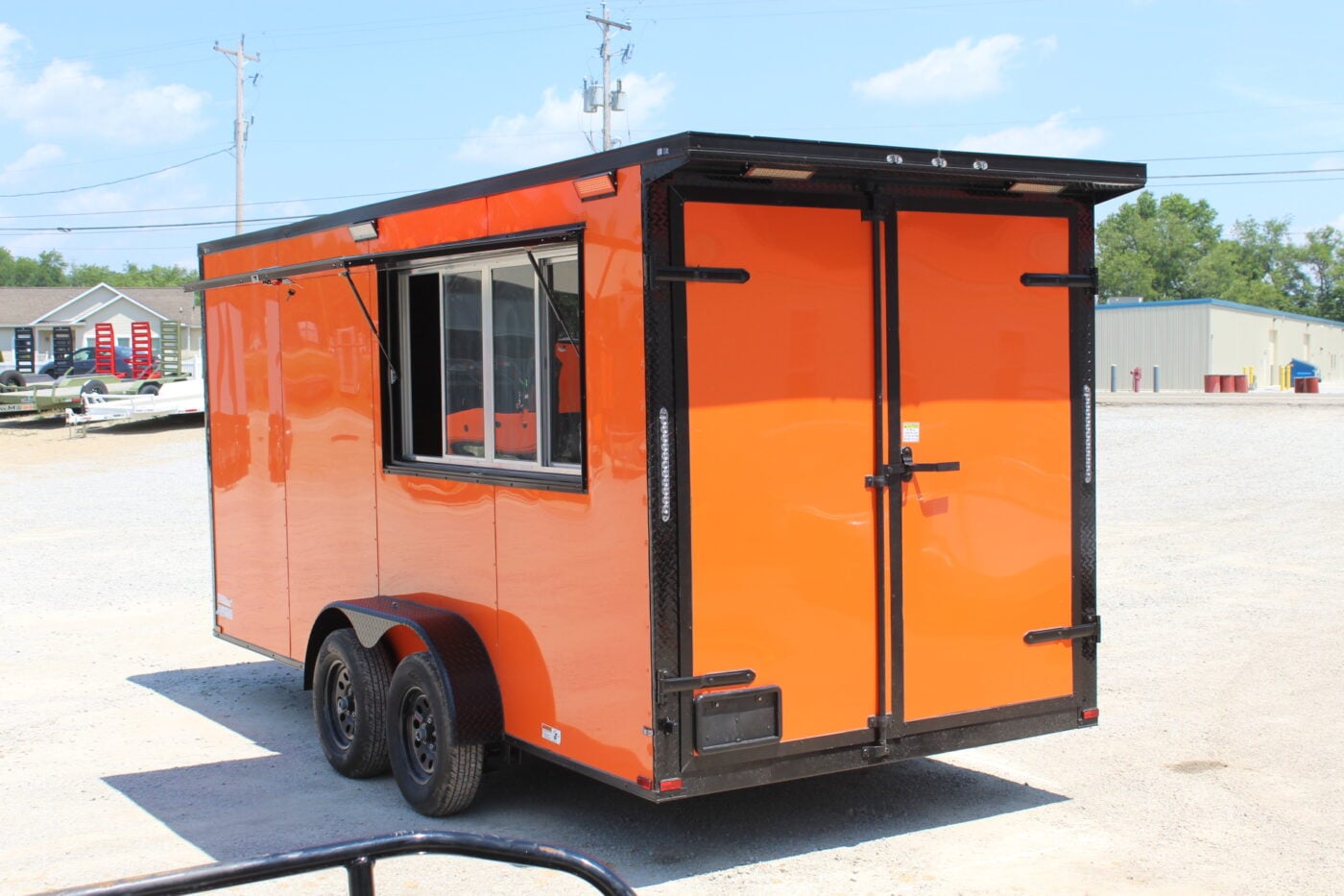 Bright orange enclosed cargo trailer with serving window