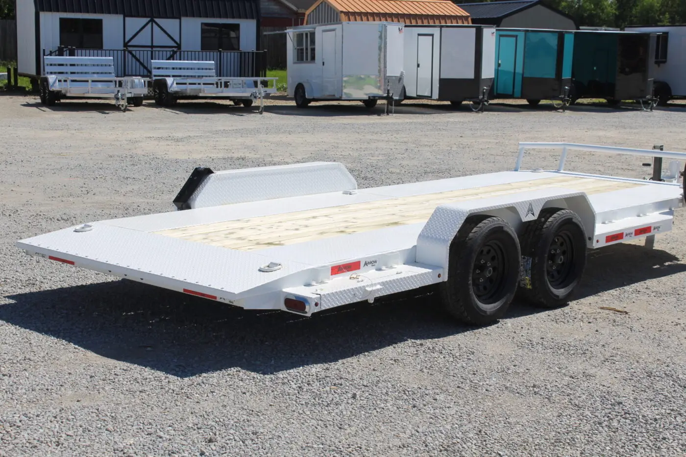 White dual-axle flatbed car hauler trailer