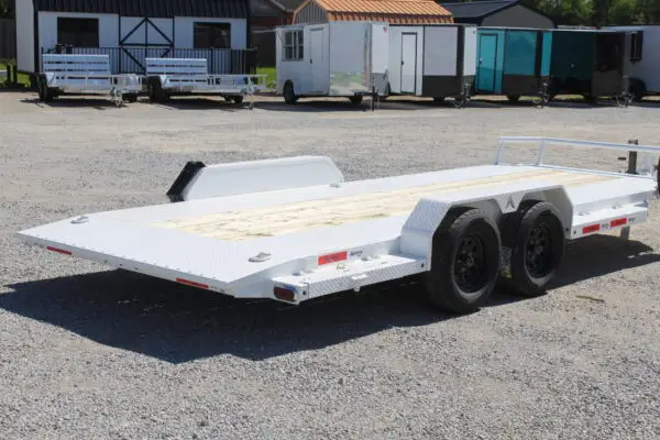 White dual-axle flatbed car hauler trailer