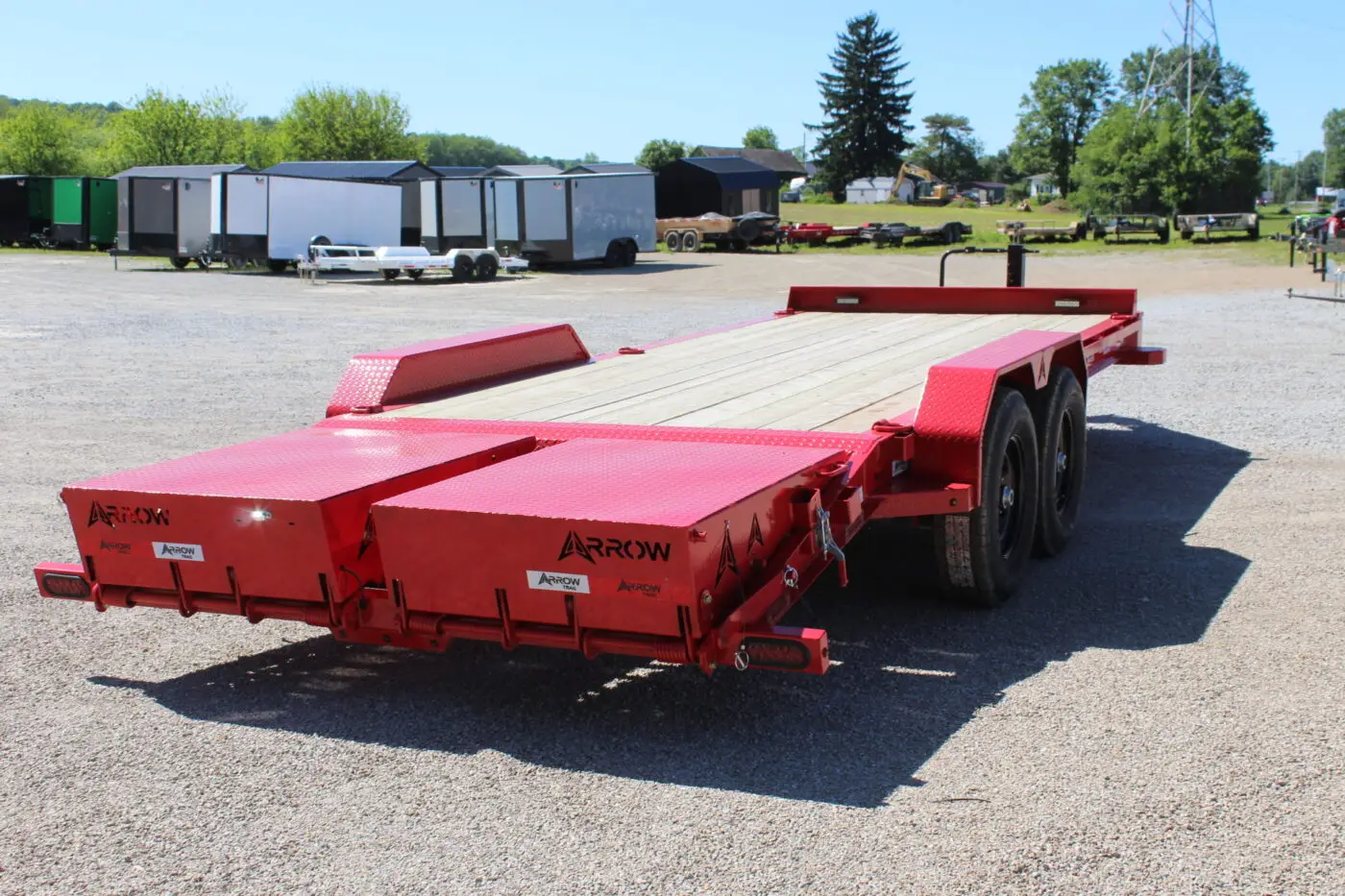 Red flatbed equipment trailer on gravel lot