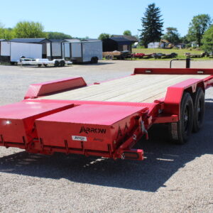 Red flatbed equipment trailer on gravel lot