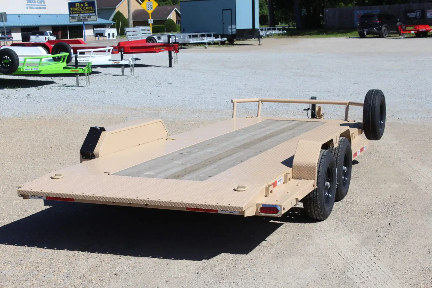 Tan dual-axle flatbed car hauler trailer