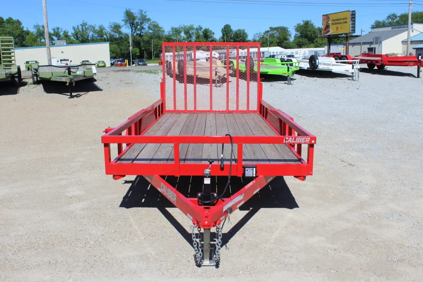 Red utility trailer with mesh ramp gate