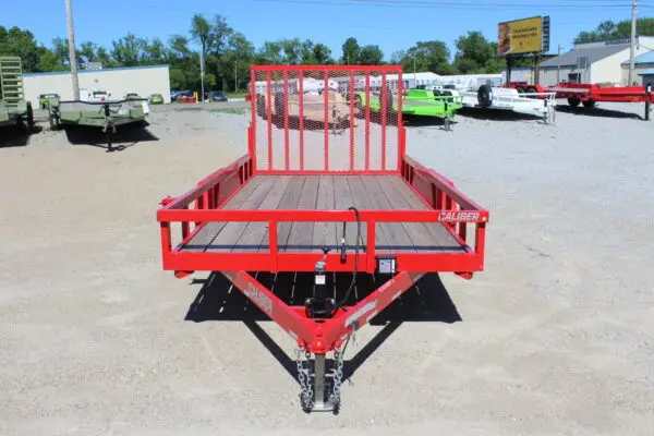 Red utility trailer with mesh ramp gate