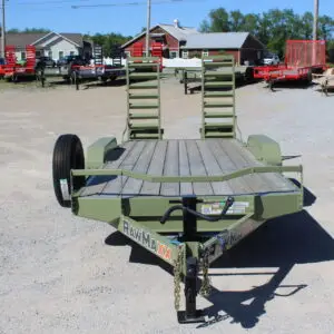 Green utility trailer with ramps on gravel lot