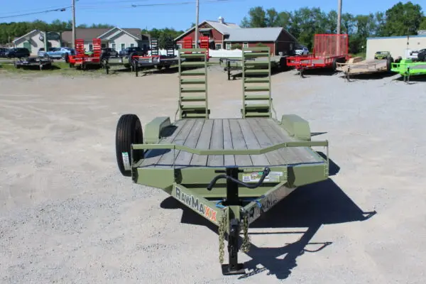 Green utility trailer with ramps on gravel lot
