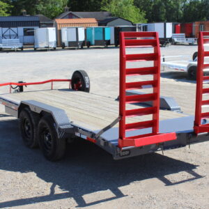 Flatbed equipment trailer with red loading ramps