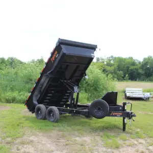 Black dump trailer with raised bed in field