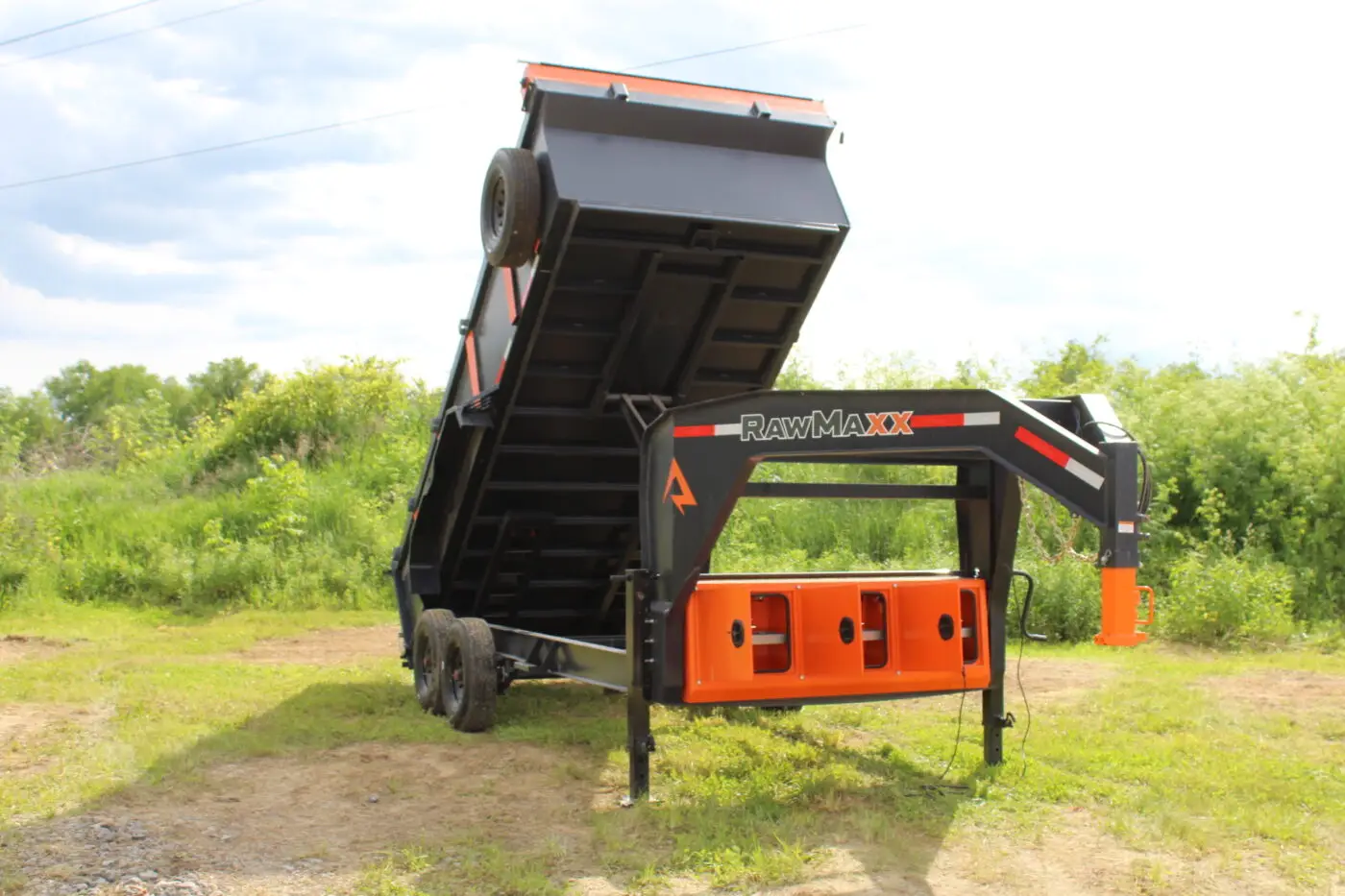 Black and orange gooseneck dump trailer raised