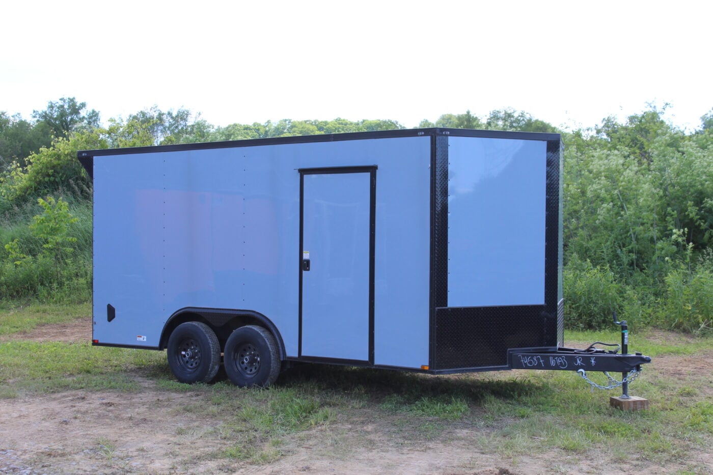 Silver enclosed cargo trailer on grassy field