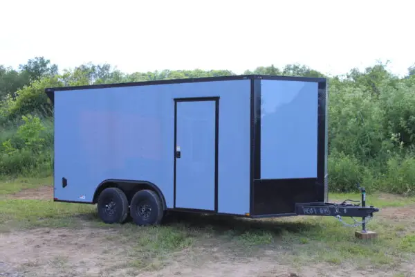 Silver enclosed cargo trailer on grassy field