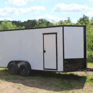 White enclosed cargo trailer parked on grass
