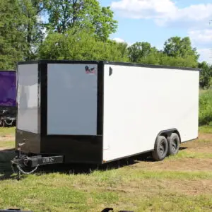 White enclosed cargo trailer on grassy lot