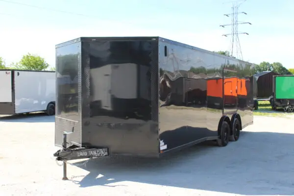 Black enclosed cargo trailer on gravel lot
